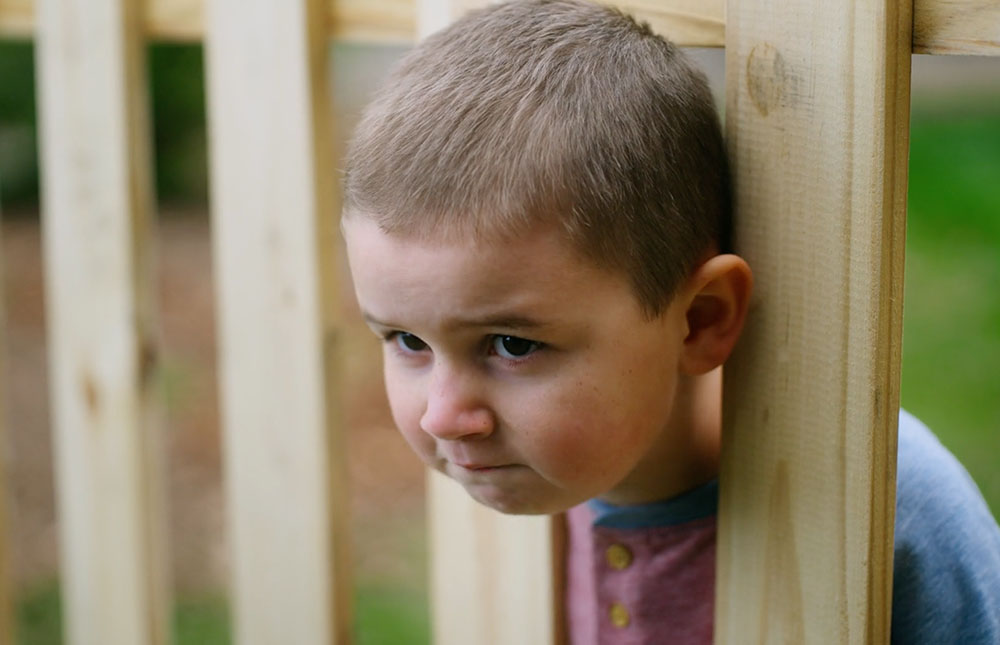 Image of little boy stuck in fence